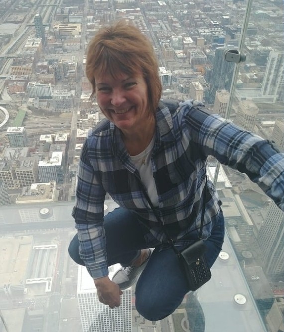 image of a woman crouched down on a glass floor over a cityscape
