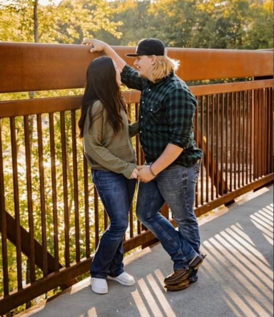 image of a couple standing in front of a brown wooden fence