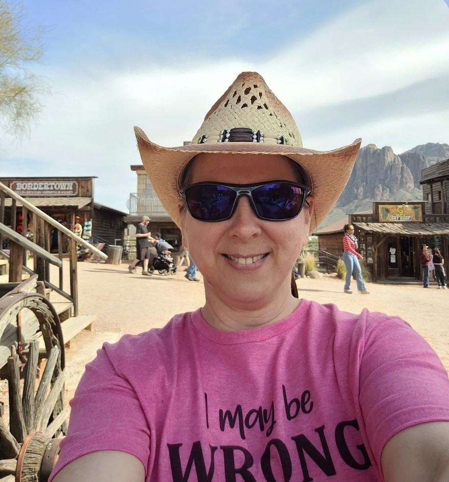 image of a woman in a pink t-shirt, sunglasses and a cowgirl hat